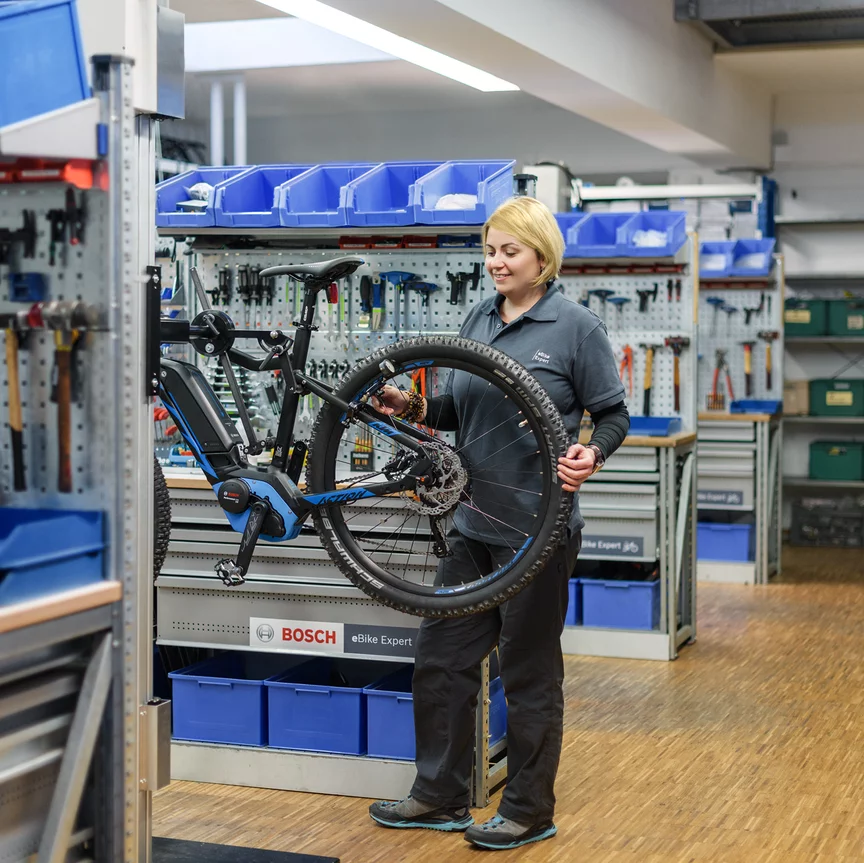 En eBike-mekaniker inspiserer en elsykkel på Bosch-verkstedet.