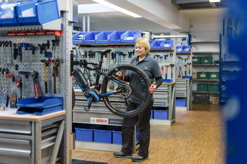eBike Mechanikerin kontrolliert ein eBike in der Bosch Werkstatt.