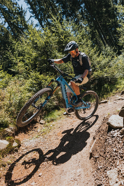 An eBiker performing a wheelie around the curve.