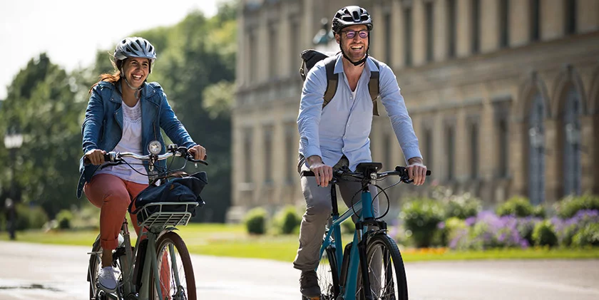 Two individuals on eBikes are cycling through the city.