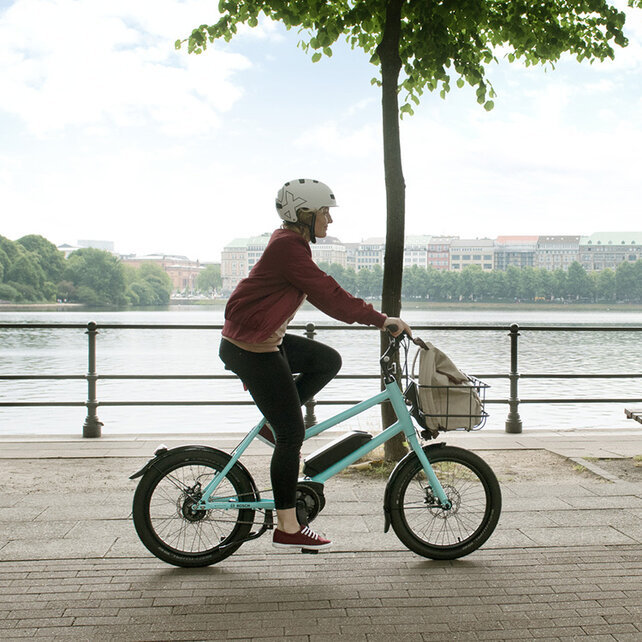 eBike Fahrerin fährt an der Elbe entlang.