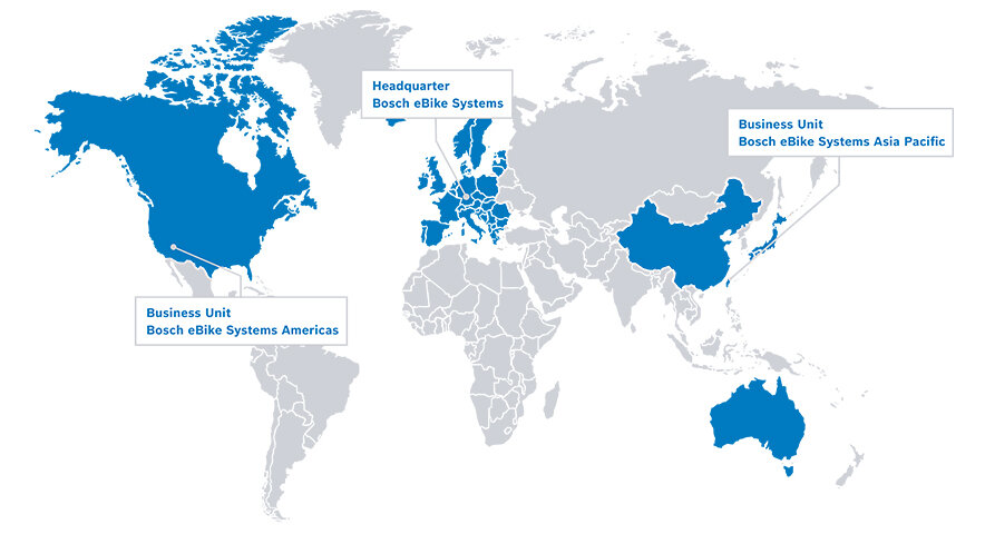 Mapa del mundo en blanco y gris, con regiones azules para América del Norte, Europa, China, Taiwán, Japón y Australia. Desde Estados Unidos, un globo de diálogo muestra el texto "Unidad de Negocio Bosch eBike Systems Americas", desde Europa el texto "Sede Central Bosch eBike Systems" y desde Taiwán el texto "Unidad de Negocio Bosch eBike Systems Asia Pacific".