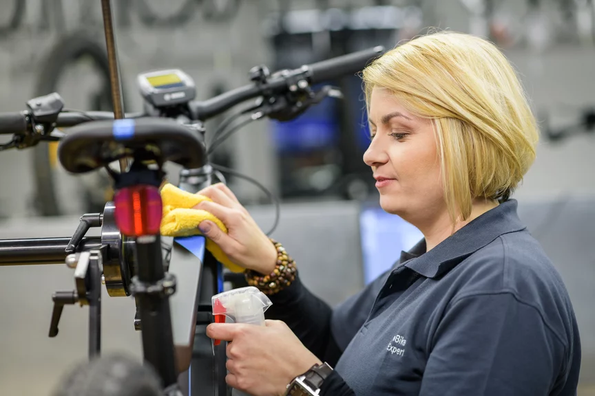 Eine eBike Händlerin putzt den Rahmen eines eBikes.