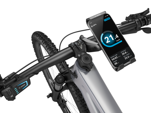 Close-up of the handlebars of an eBike, featuring a SmartphoneGrip Vertical with a smartphone inserted on the right.