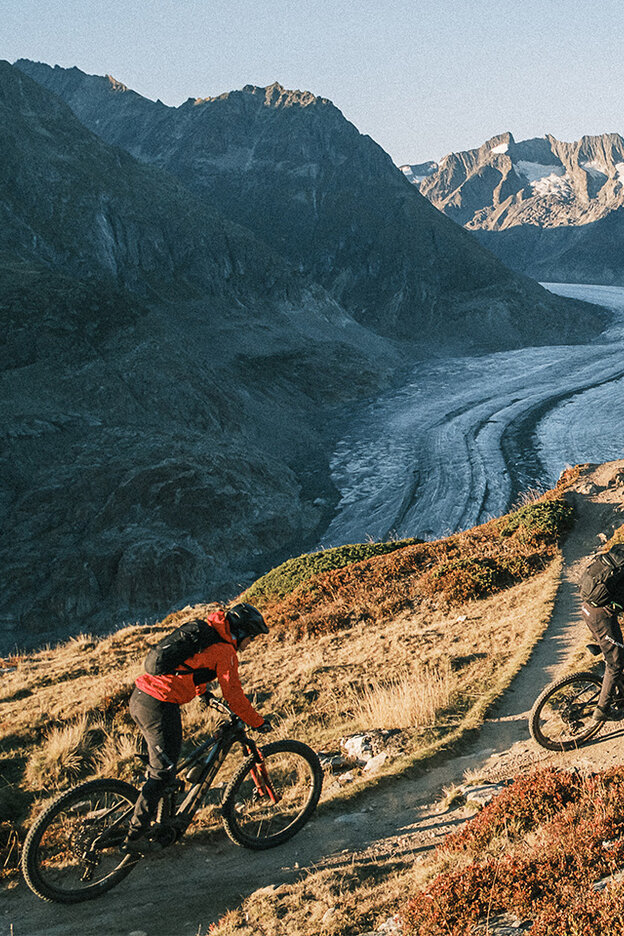 Zwei eMountainbike Fahrer fahren einen Berg hinauf.
