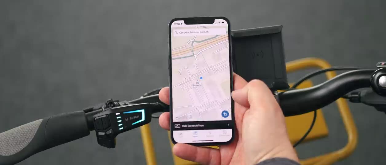 Zusammenschnitt bei dem die Navigation mit dem Smartphone per eBike Flow App gestartet wird. Anschließend wird das Smartphone an dem SmartphoneGrip befestigt. Daraufhin folgt eine Fahrszene bei der der Ride Screen der eBike Flow App zu sehen ist und am Ende wird das Smartphone aus der Halterung entommen. 