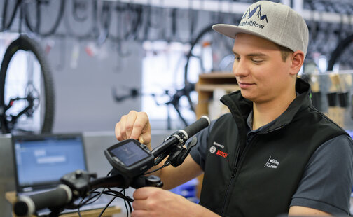 eBike Experte nimmt in der Werkstatt Einstellungen am Nyon-Display vor.
