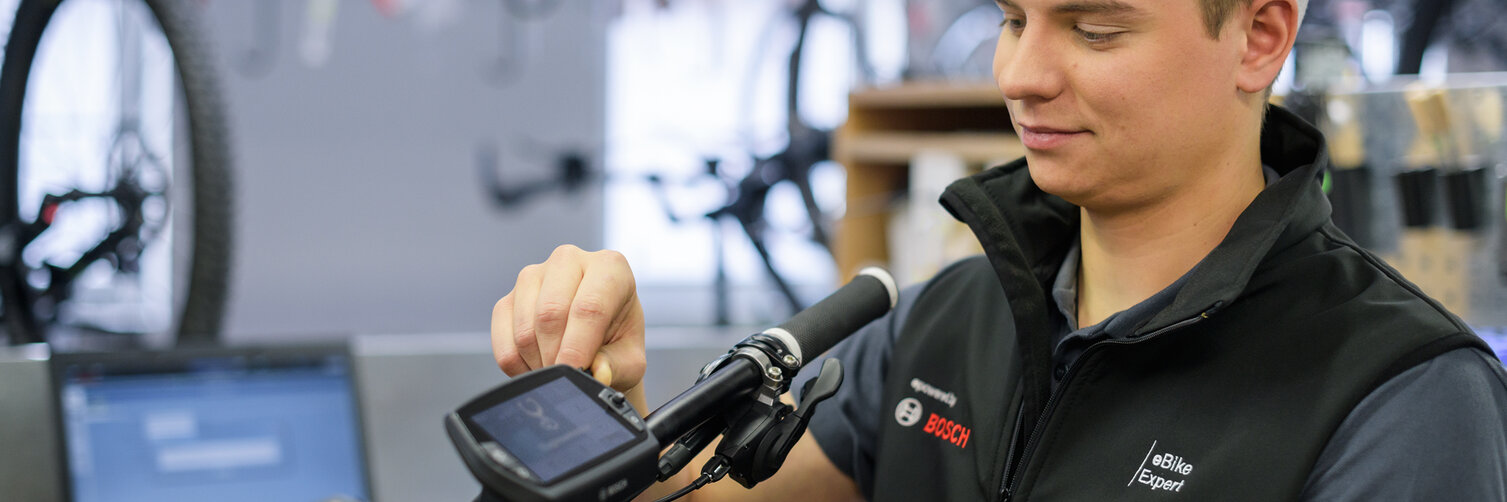 The eBike expert is making adjustments to the Nyon display in the workshop.