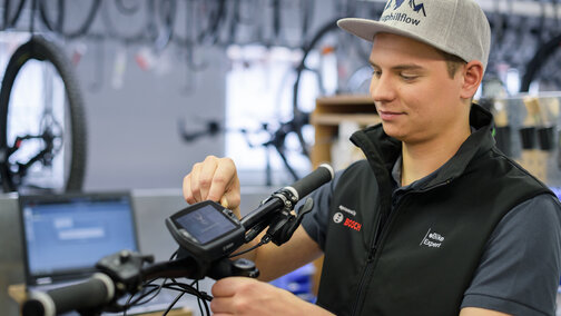 The eBike expert is making adjustments to the Nyon display in the workshop.