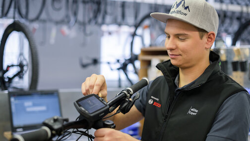 eBike Experte nimmt in der Werkstatt Einstellungen am Nyon-Display vor.