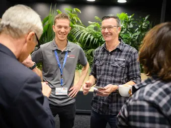 Two men, both wearing tops with the Bosch logo, stand opposite two people and smile.