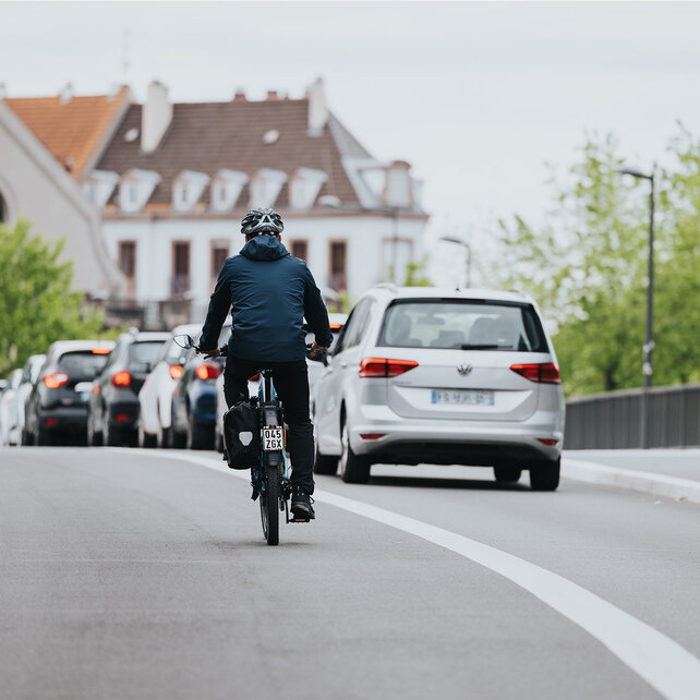 eBiker si dirige verso una fila di auto ferme.