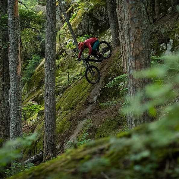 Il conducente di eBike scende lungo un ripido pendio nel bosco.
