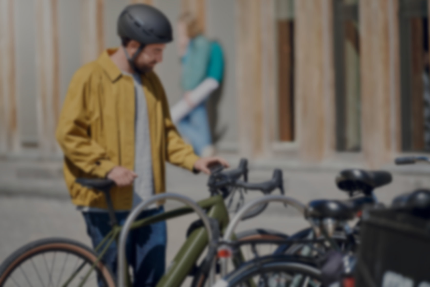 Ein eBiker stellt sein Pedelec in der Stadt an einem Fahrradständer ab