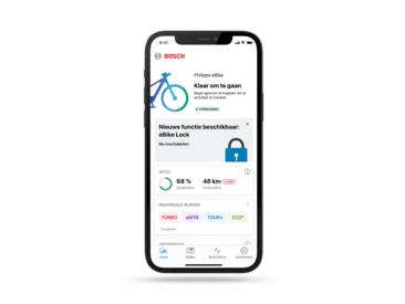 Een smartphone uitgesneden tegen een grijze achtergrond. Het display toont de homepagina in de geopende eBike Flow-app.