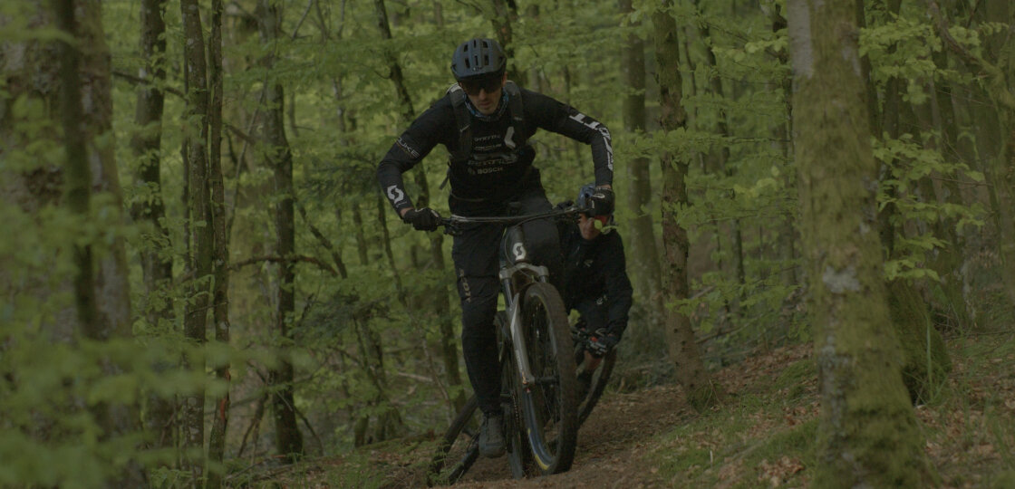 Deux Vététiste roulent l’un derrière l’autre à travers la forêt.