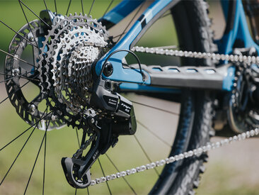 A close-up of the chain shifting system of a bicycle rear wheel with Bosch eShift and TRP system is visible.