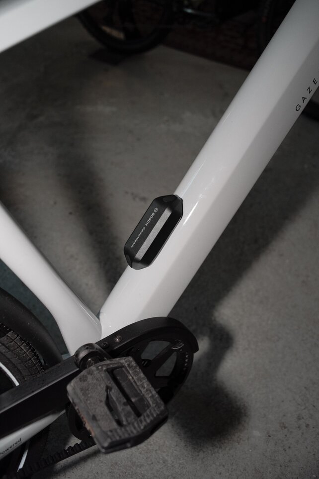Primer plano de un marco de eBike blanco con un ConnectModule instalado para protegerte del robo.