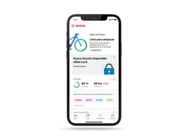 Un teléfono recortado sobre un fondo gris. El display muestra la página de inicio en la aplicación eBike Flow abierta.