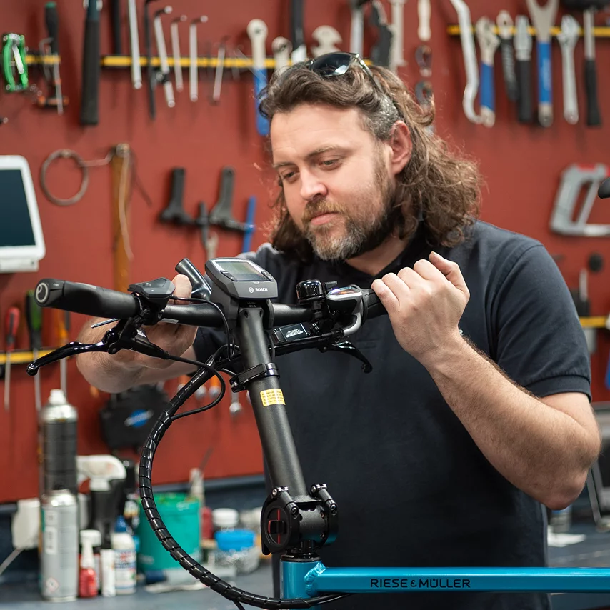 Bike Mechanic installing a Bosch eBike System Display unit on a blue bike