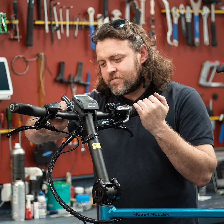 Bike Mechanic installing a Bosch eBike System Display unit on a blue bike