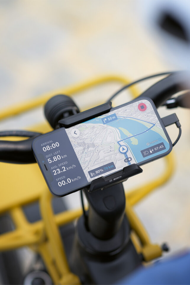 Chytrý telefon je připevněn k držáku na řídítkách jízdního kola a slouží jako displej eBiku pro navigaci, zobrazuje informace o trase a navigační pokyny.