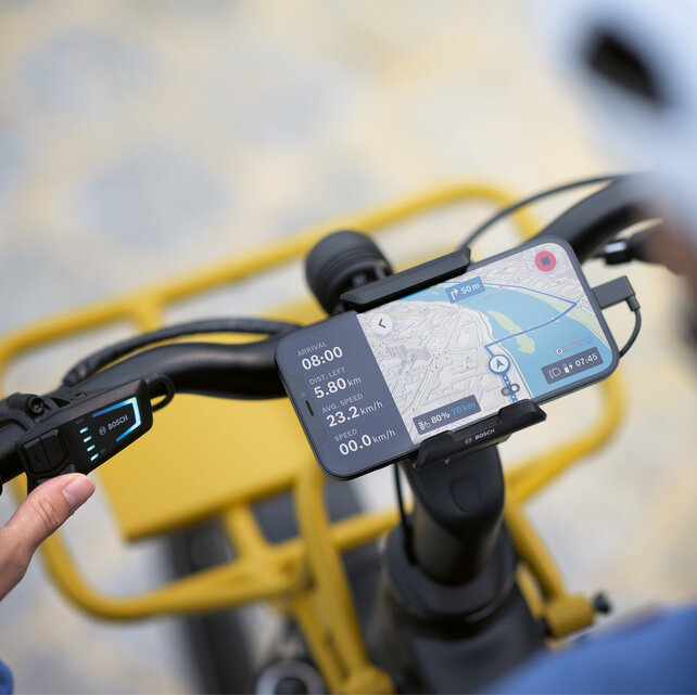 Smarttelefonen er festet til en holder på sykkelstyret og brukes som et eBike-display for navigasjon, og viser ruteinformasjon og navigasjonsanvisninger.