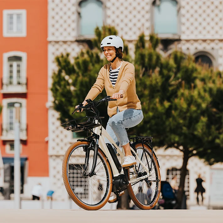 The eBiker rides happily through the city on her eBike.