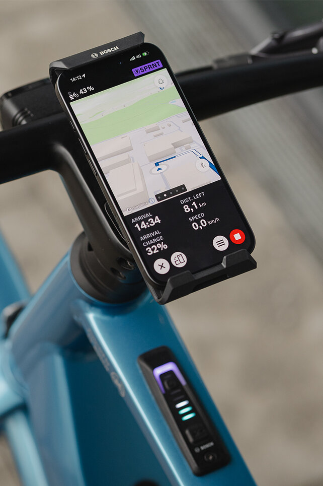Close-up of a SmartphoneGrip vertical mounted on a handlebar. The smartphone is in navigation mode and shows a route guide.