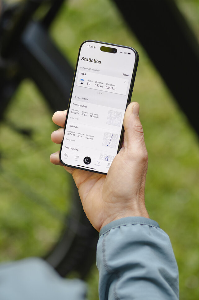 Guardando oltre la spalla di un uomo che consulta le sue statistiche nell'app eBike Flow.