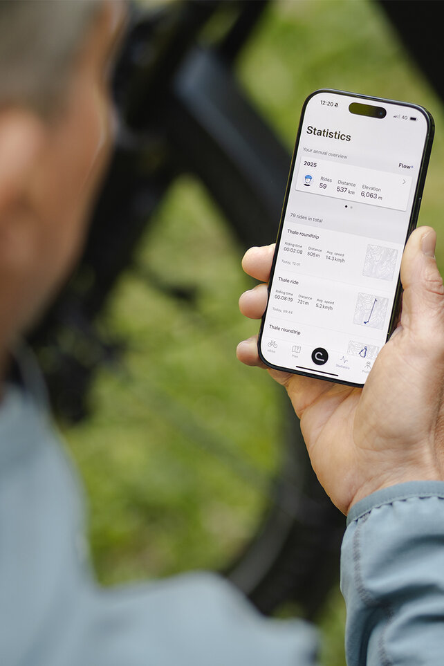 Looking over the shoulder of a man checking his stats in the eBike Flow app.