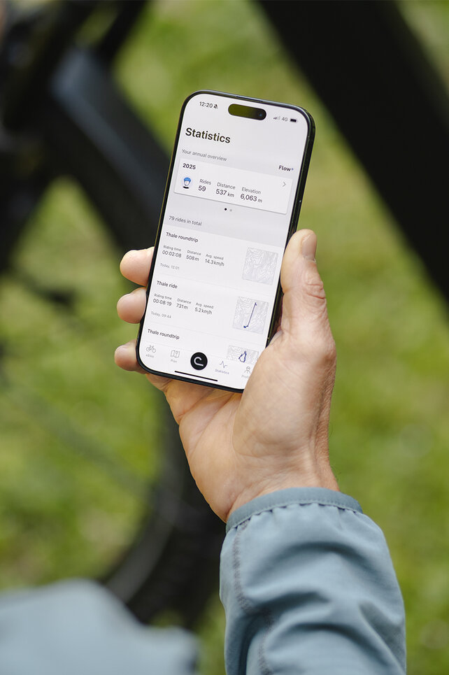 Looking over the shoulder of a man checking his stats in the eBike Flow app.
