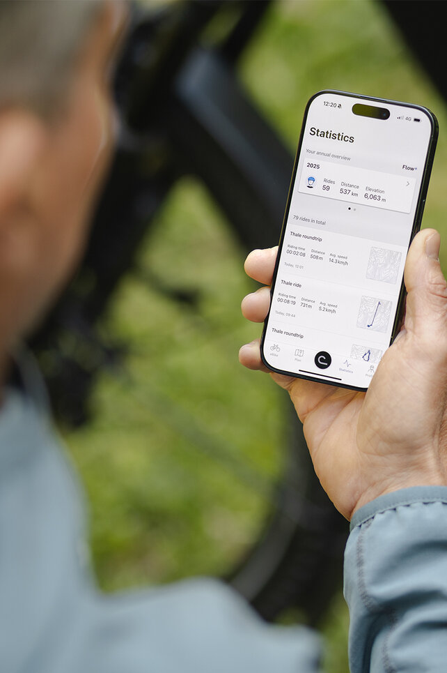 Looking over the shoulder of a man checking his stats in the eBike Flow app.