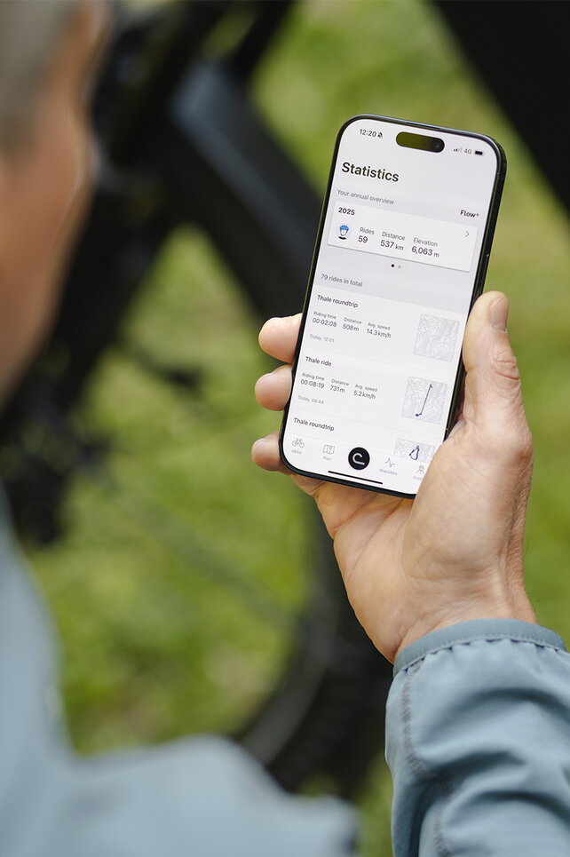 Looking over the shoulder of a man checking his stats in the eBike Flow app.