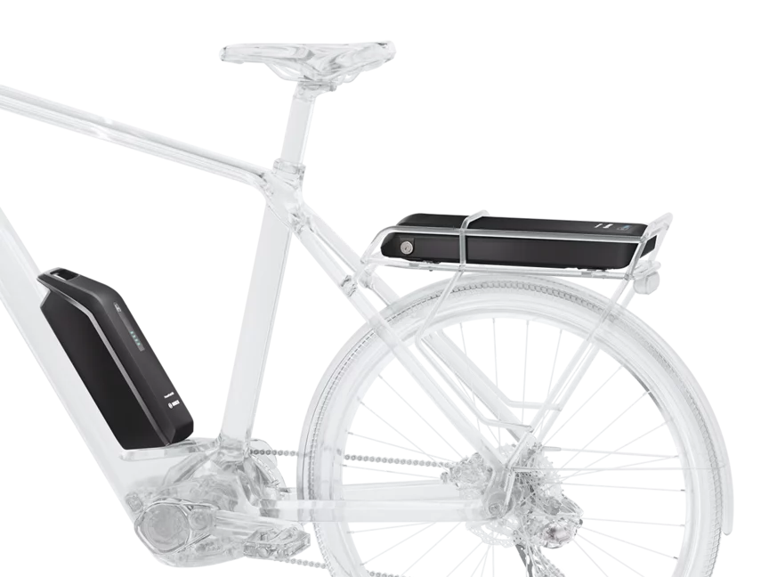 An eBike model with a glass design shows how the Bosch PowerPack rack is positioned and integrated on the luggage rack, and the PowerPack Frame is placed on the frame. Both batteries are highlighted in black to demonstrate the DualBattery function, which means combining two batteries.