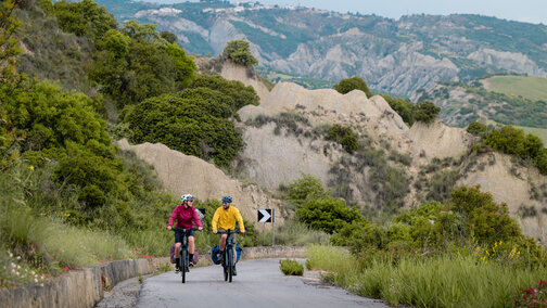 Une femme et un homme gravissent une montagne avec leurs eBikes.