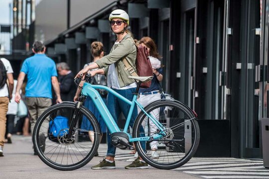 Woman uses a Bosch powered electric bike for commuting to work. 