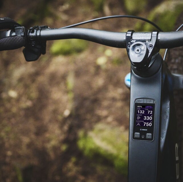 Close-up of the Bosch Kiox 400C display integrated into an eMTB. It shows ride data such as the eMTB mode, 80% battery, power, and the altitude already covered.