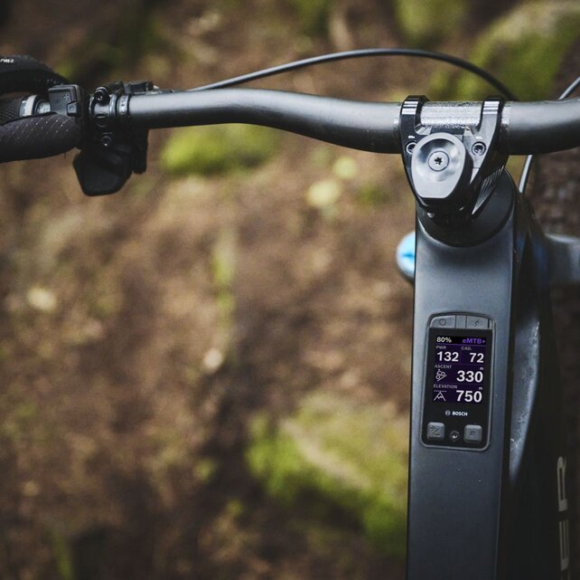 Nærbilde av Bosch Kiox 400C-skjermen integrert i en eMTB. Den viser turdata som eMTB-modus, 80 % batteri, kraft og allerede tilbakelagte høydemeter.
