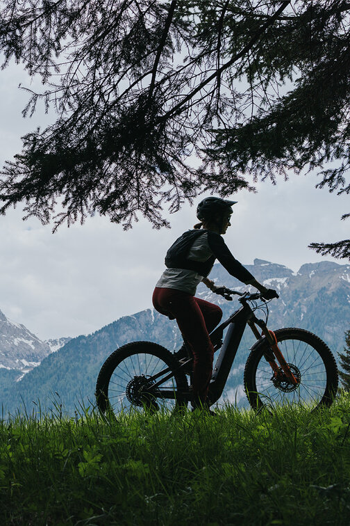 An eBiker riding on a mountain meadow and a mountain path in South Tyrol.