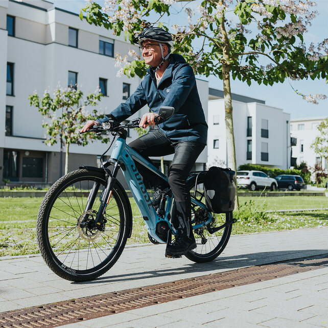 L'uomo guida la sua eBike oltre una zona residenziale.