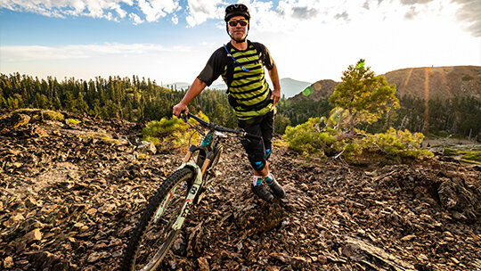 Man standing with his eMTB on a rocky hill