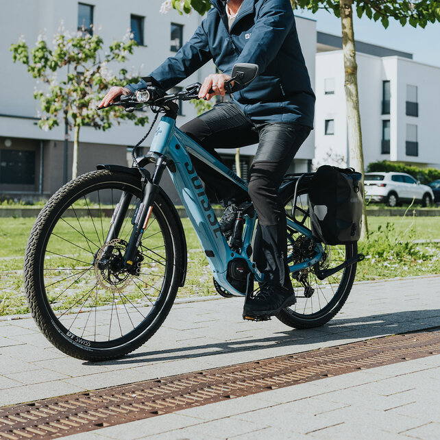 Man rides past a residential area on his eBike.