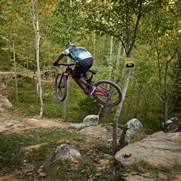 A mountain biker leaps over rocks on a trail in Bentonville, Arkansas.