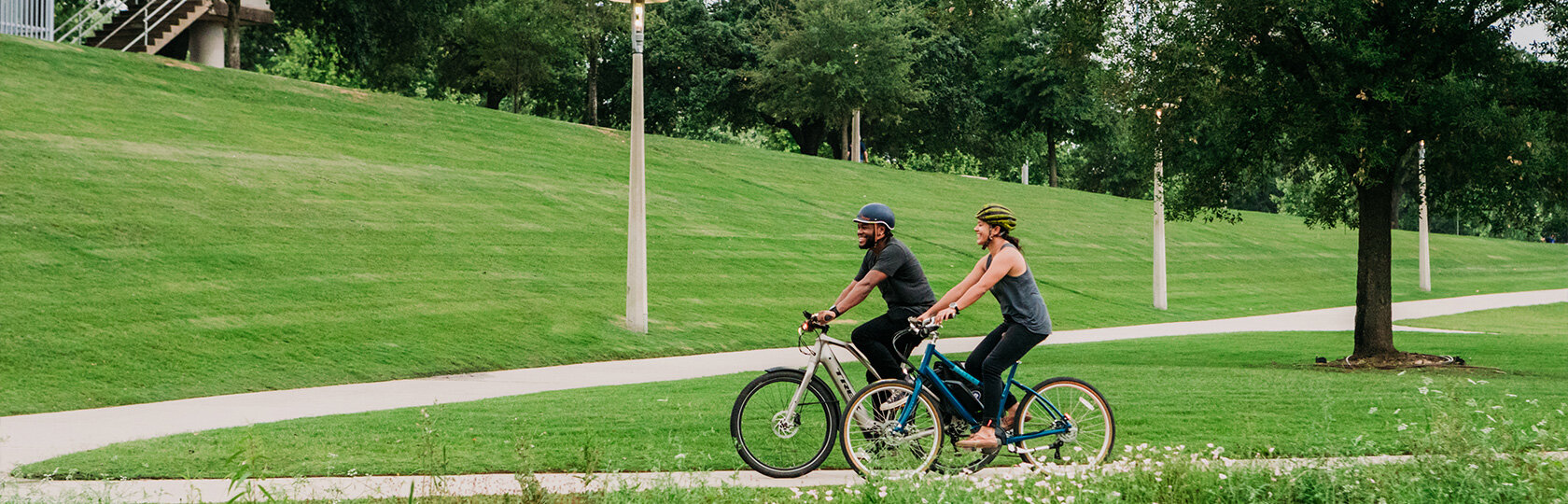 A man and a woman are enjoying a ride on eBikes powered by Bosch in a park near Houston, Texas.