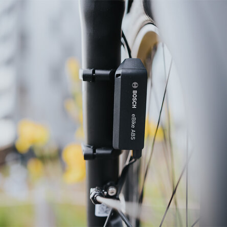 Primo piano di un sensore Bosch eBike ABS nero montato sulla forcella di una bicicletta.