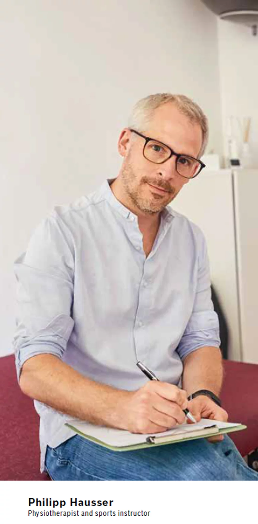 Philipp Hauser looks into the camera and writes on a clipboard.