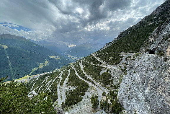 Paesaggio montano attraversato da una strada tortuosa.
