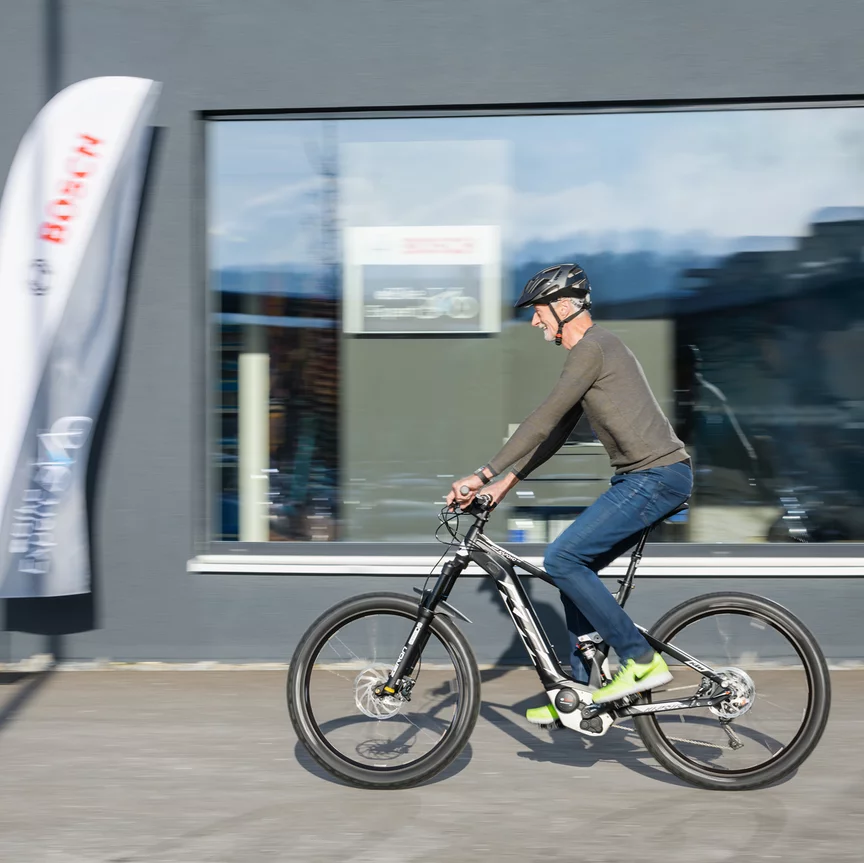 An eBike rider rides past a Bosch bicycle store.