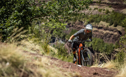 Ein eBiker fährt auf einem Trail den Berg hoch